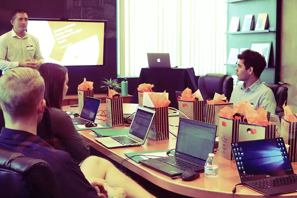 students around a table with computers