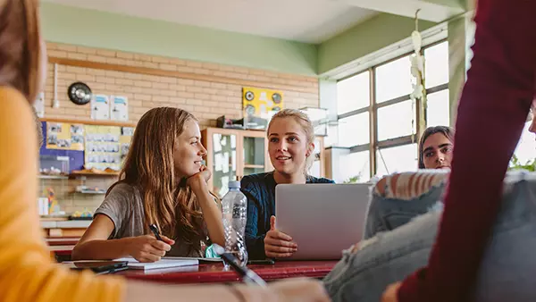 Happy students using technology in the classroom